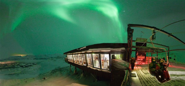 Aurora Sky Station building on a mountain ridge beneath northern lights