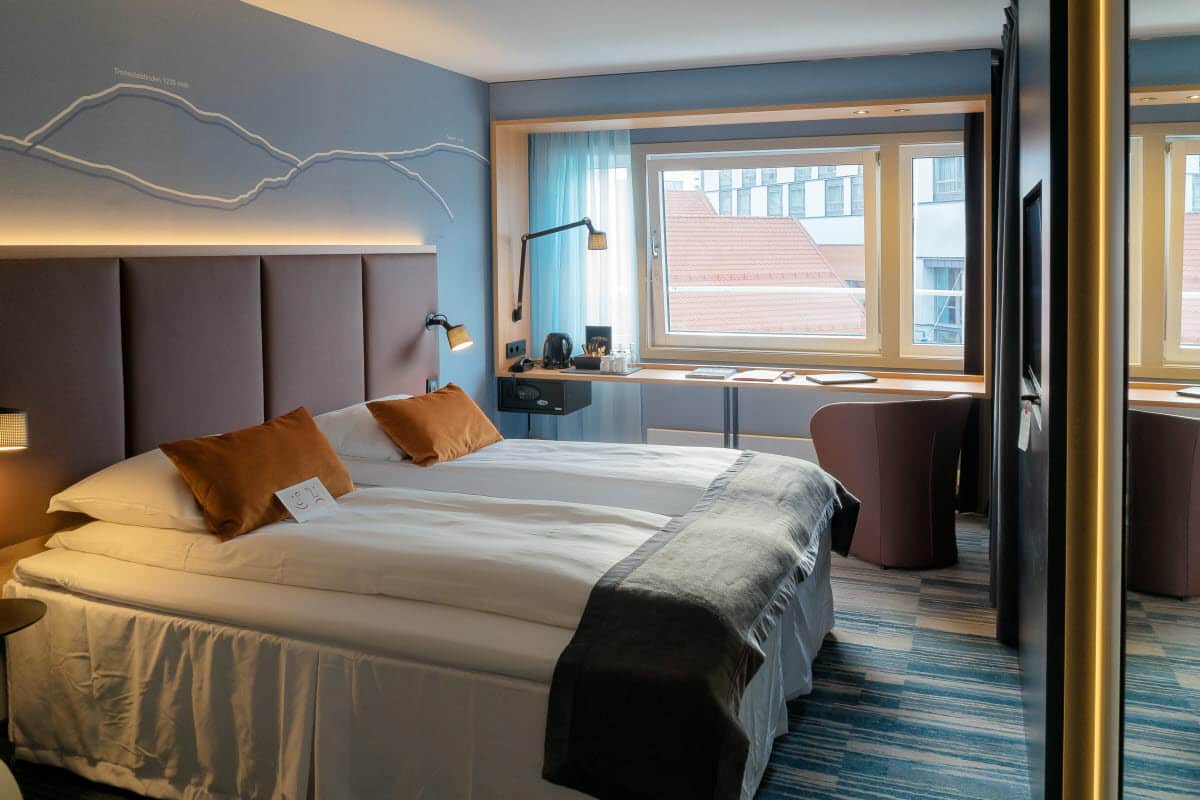 Standard Scandic Ishavshotel room with a double bed, desk, armchair and large window