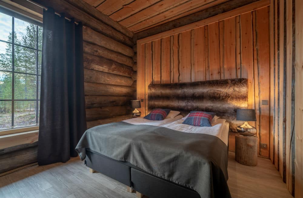double bedroom in a log cabin with a large window