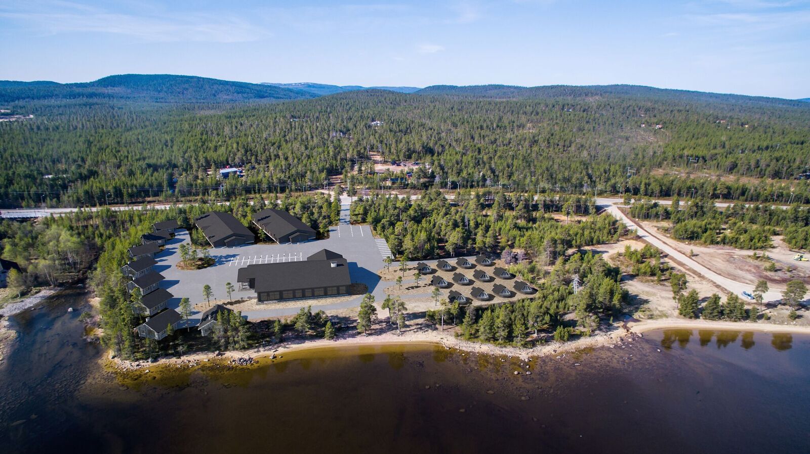 Aerial view of a lakeside resort surrounded by forest and water in daylight