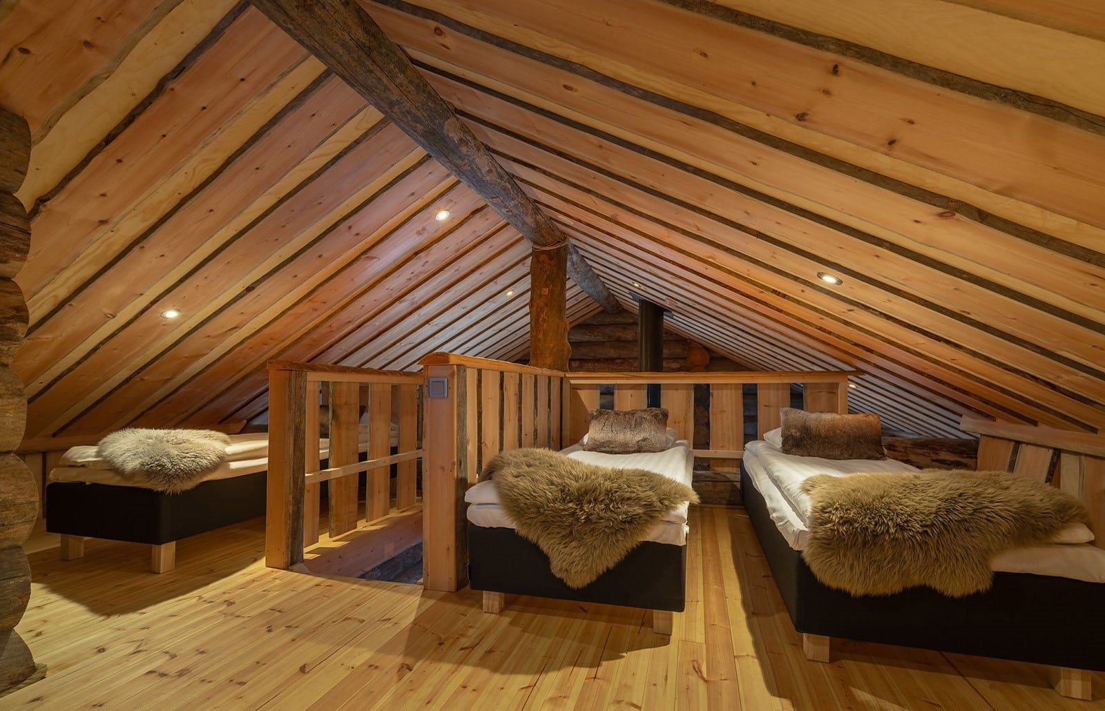 Cozy log cabin loft bedroom with twin beds, wooden beams and sloped ceiling