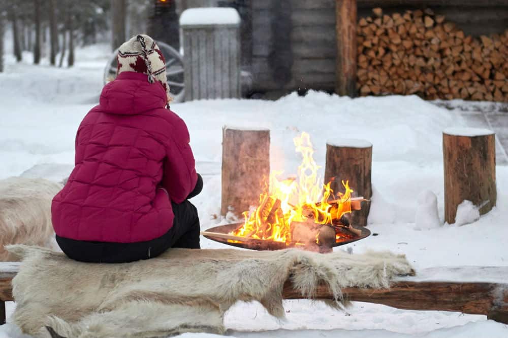 woman sat by campfire