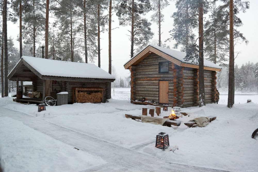 arctic wooden cabins in the snow with campfire