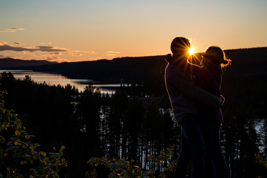 2 people hugging with view of trees and river