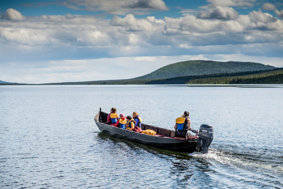 people on a boat in the summer with hills in the distance