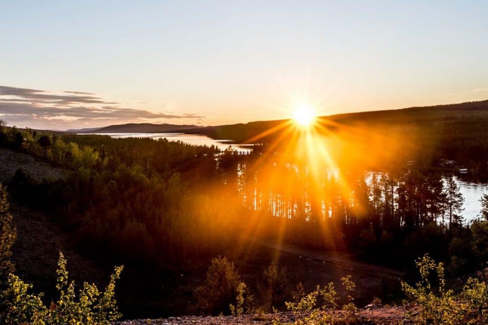 Sunset over lakes and forest, with golden light reflecting on the water