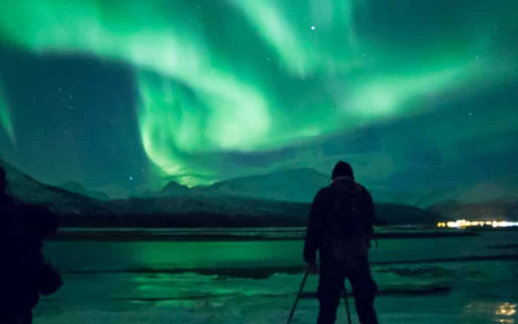 person taking photo of northern lights
