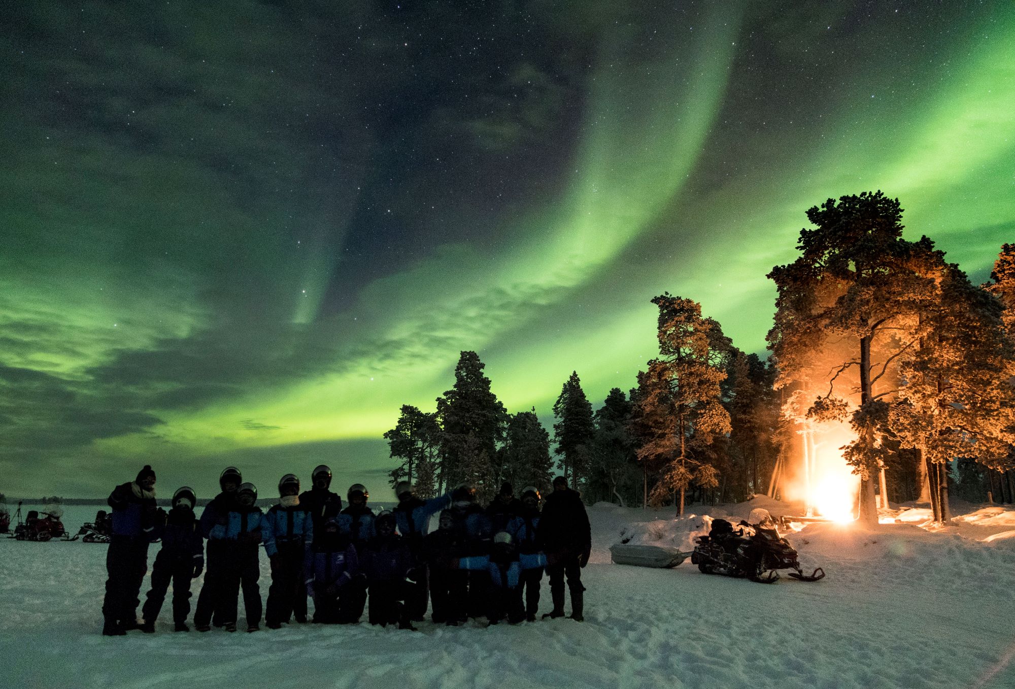 people stood in a group watching the northern lights
