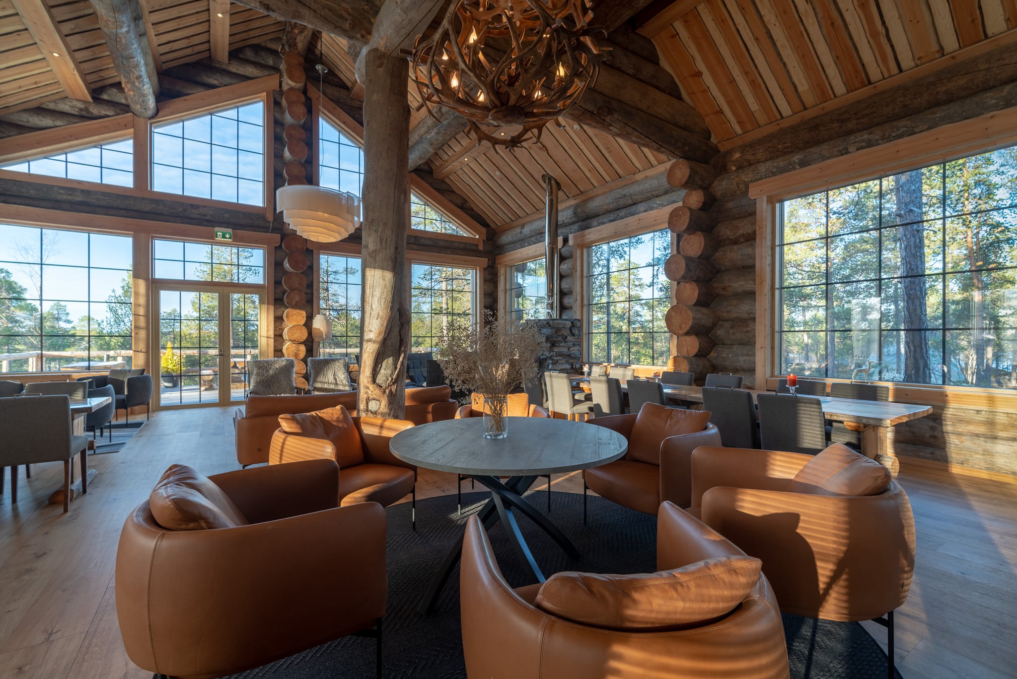 lounge restaurant area in a large log cabin with high ceilings and panoramic windows