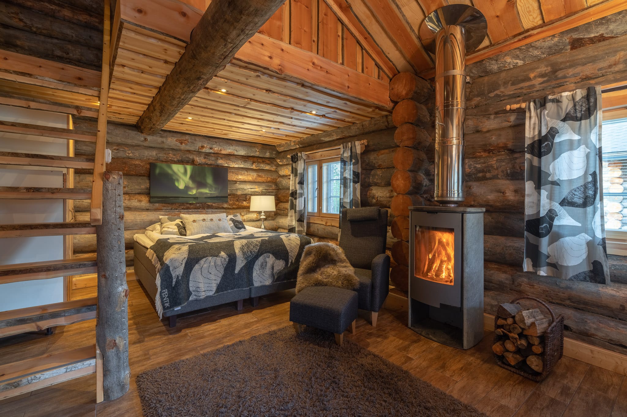 double bed with arm chair and log burner at the end of the bed