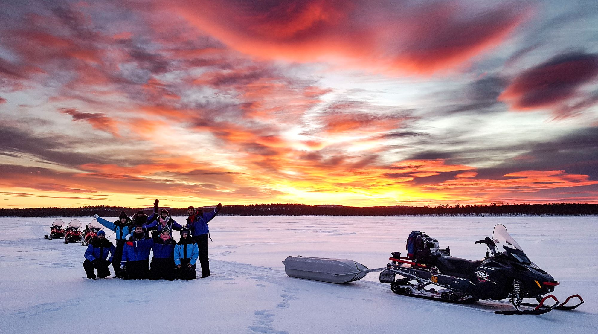 snowmobiling with red and orange sky