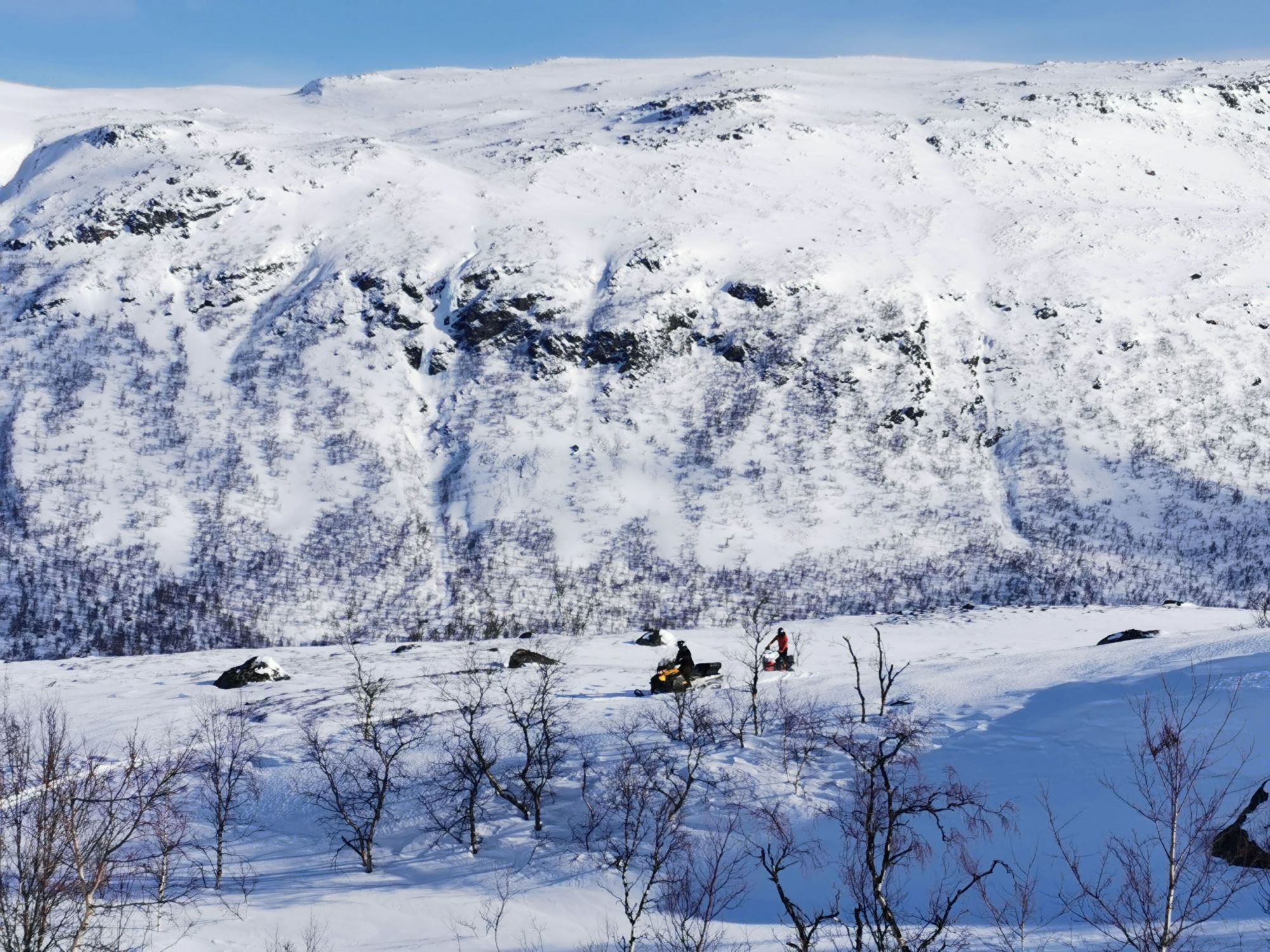 snowmobiling below the snowy mountains