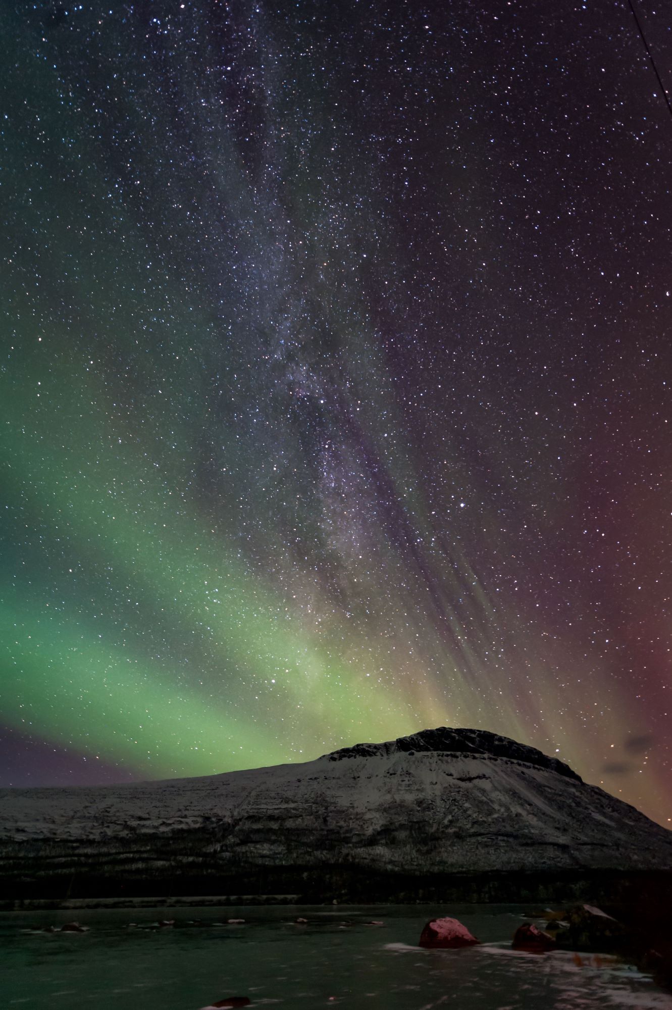 northern lights and starry sky with view of mountains
