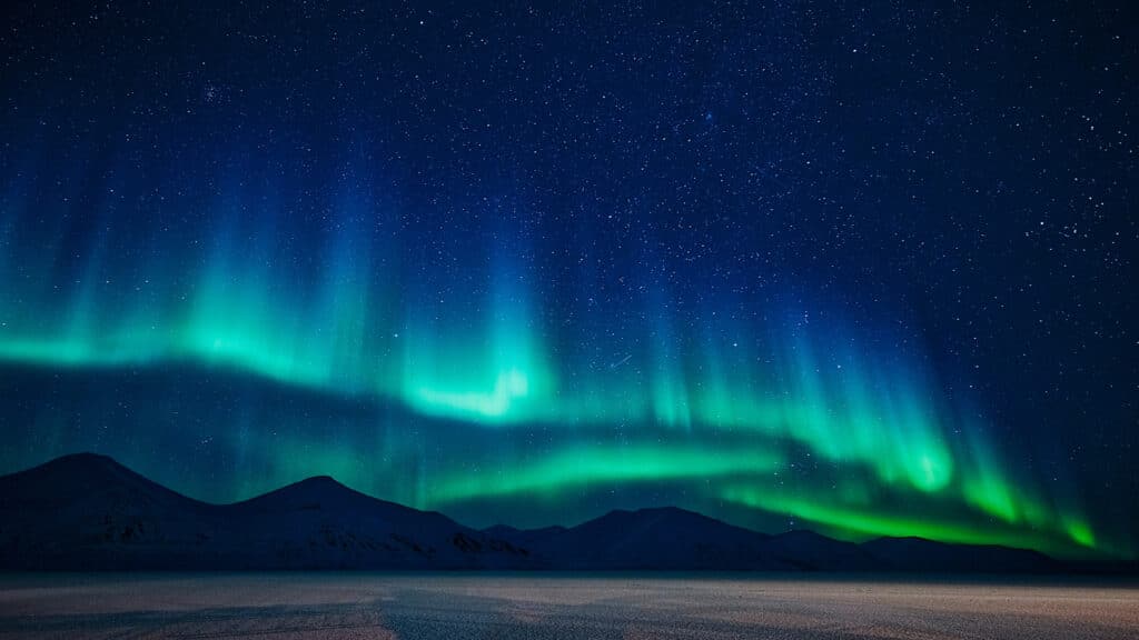 northern lights above mountains