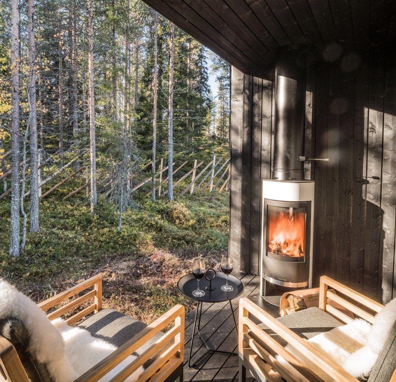2 armchairs outside log cabin with fireplace