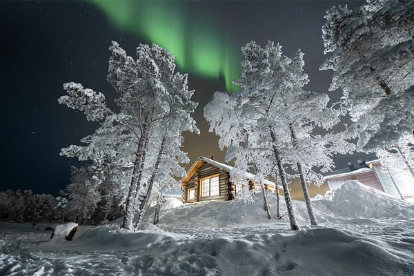 cabin in the snow with northern lights above