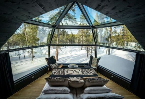 inside view of double bed in an igloo with view over the forest
