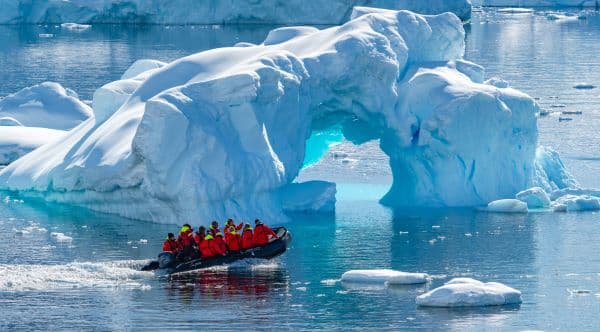 expedition boat floating past icebergs