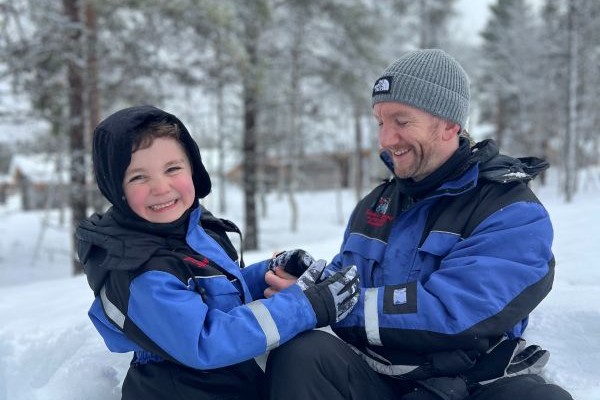 Child and dad playing in the snow at kakslauttanen