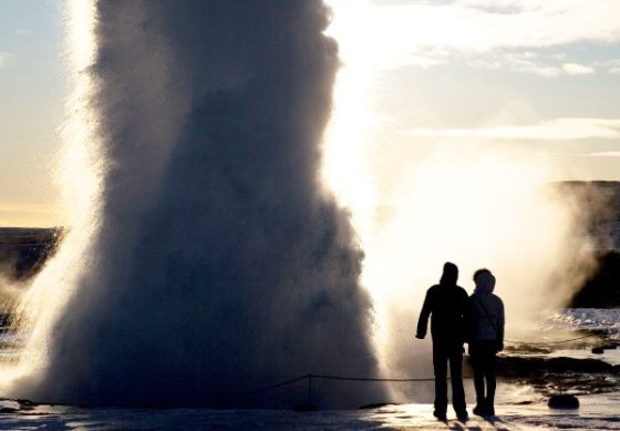 geyser erupting with people nearby