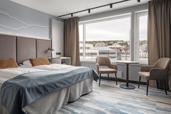 Standard Scandic Ishavshotel room with a double bed, desk, armchair and large window