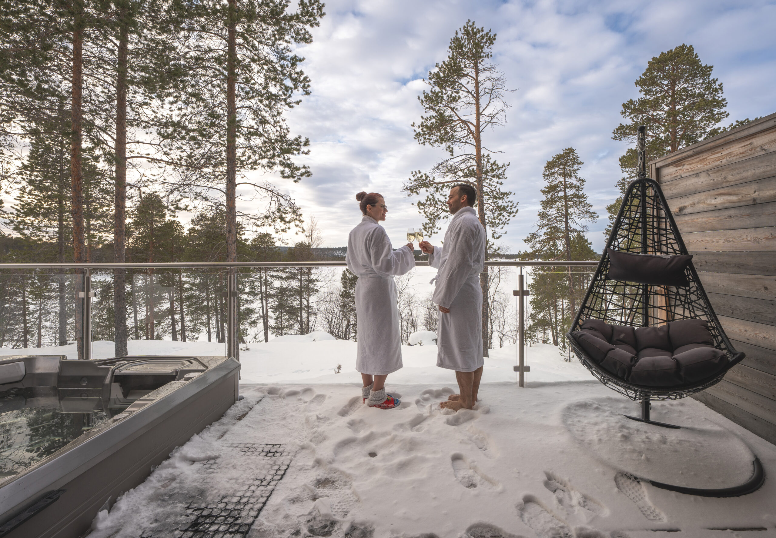 couple in robes overlooking forest from terrace
