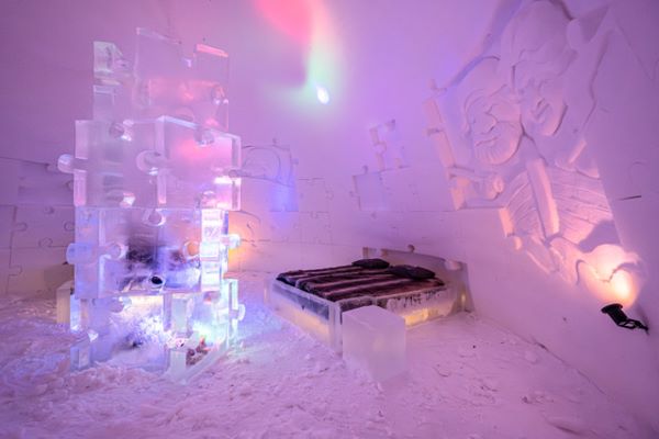 Ice hotel bedroom with ice beds decorated with snow sculptures