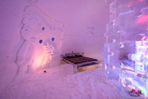 Ice hotel bedroom with ice beds decorated with snow sculptures