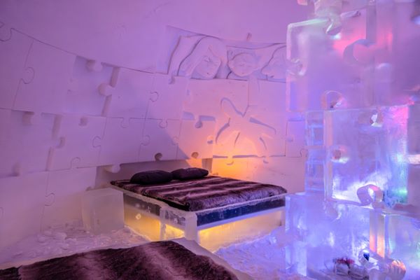 Ice hotel bedroom with ice beds decorated with snow sculptures