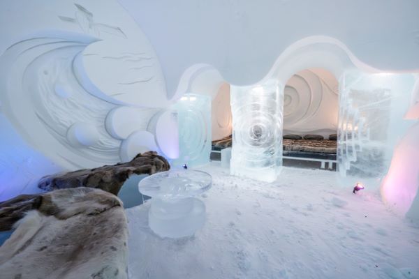 Ice hotel bedroom with ice beds decorated with snow sculptures