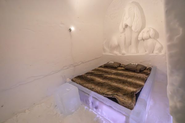 Ice hotel bedroom with ice beds decorated with snow sculptures