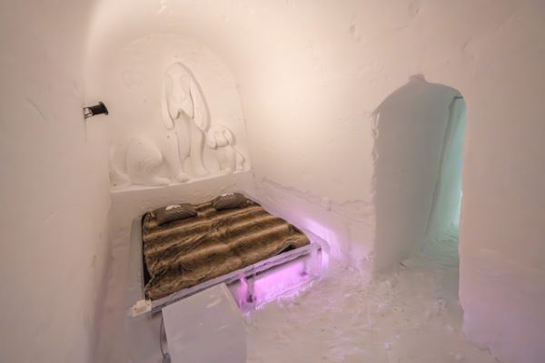 Ice hotel bedroom with ice beds decorated with snow sculptures