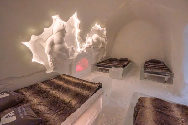 Ice hotel bedroom with ice beds decorated with snow sculptures