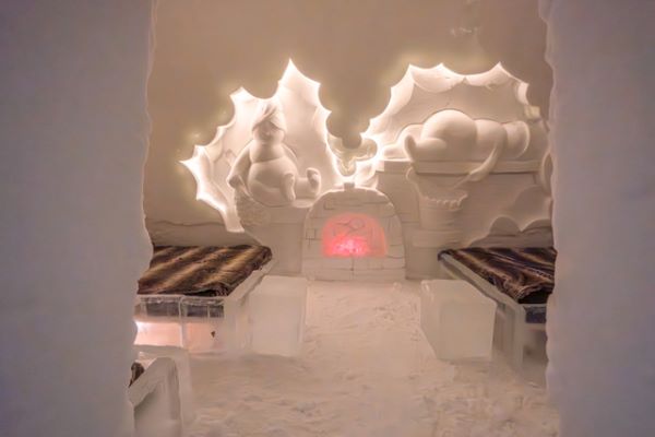 Ice hotel bedroom with ice beds decorated with snow sculptures