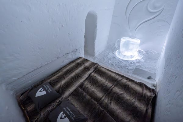 Ice hotel bedroom with ice beds decorated with snow sculptures