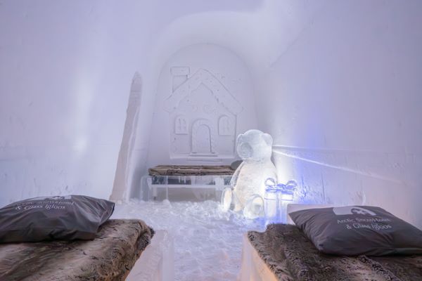 Ice hotel bedroom with ice beds decorated with snow sculptures