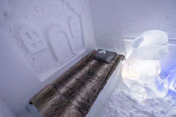 Ice hotel bedroom with ice beds decorated with snow sculptures