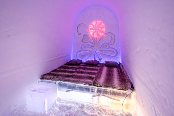 Ice hotel bedroom with ice beds decorated with snow sculptures
