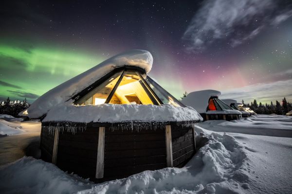 glass igloo with northern lights in the clouds