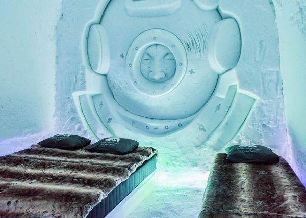 Ice hotel bedroom with ice beds decorated with snow sculptures