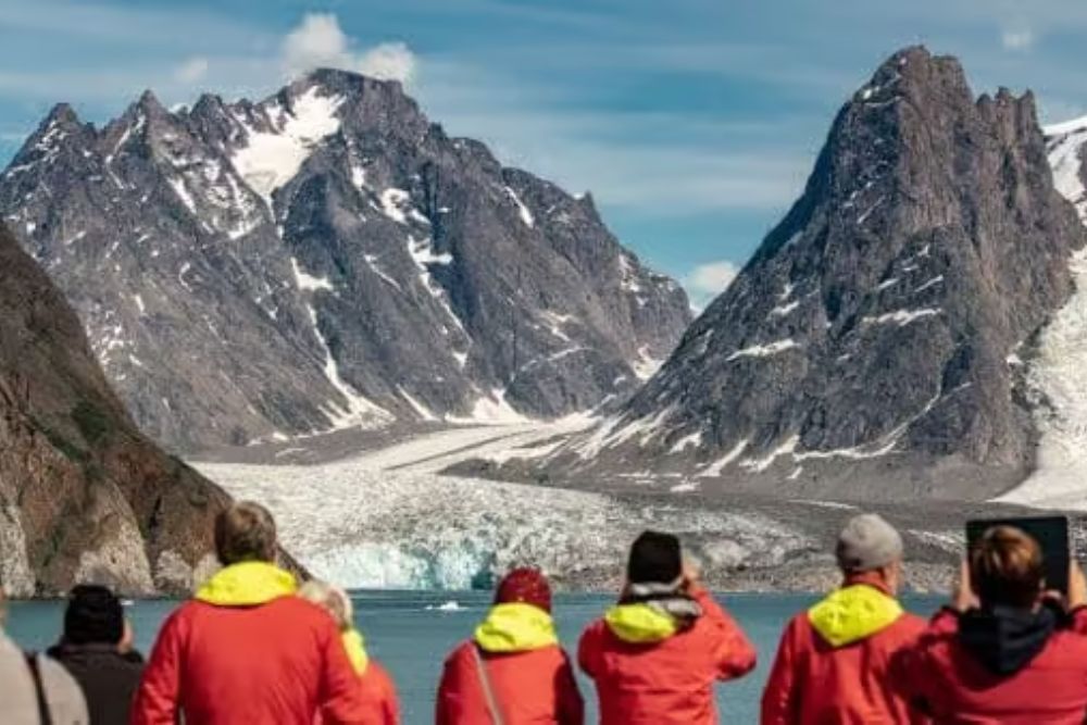 people looking at mountains in greenland