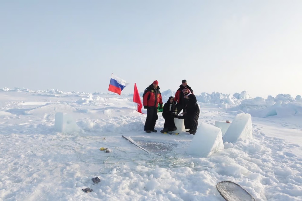 people stood with flag in the north pole