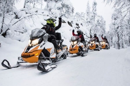 group of people snowmobiling