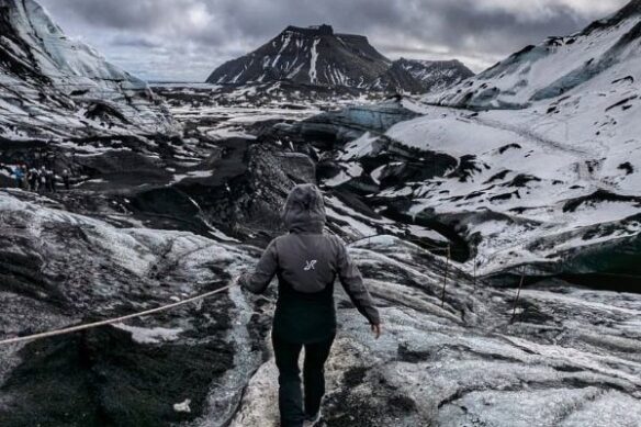 person climbing over rocky terrain in iceland