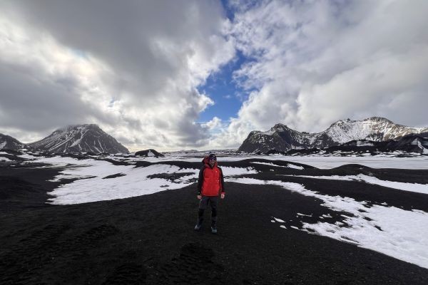person in iceland with mountains behind